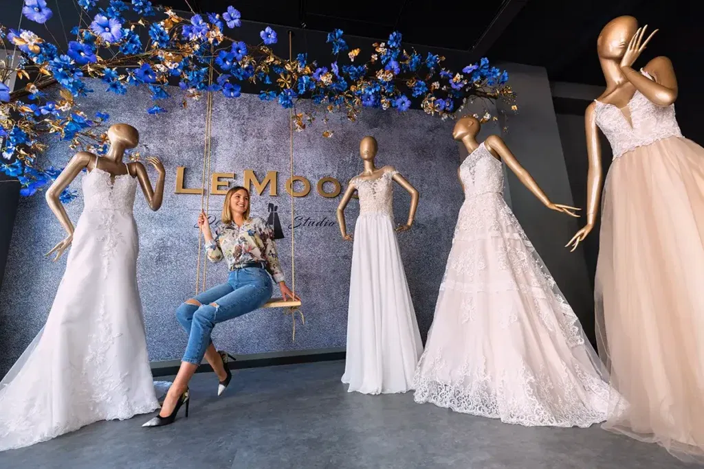 Impression photo with bridaldresses and Lena Moos sitting on a swing.