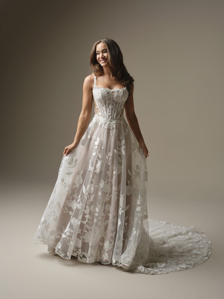 Romantische A-lijn bruidsjurk met kanten corsage en lichtroze onderrok die zacht door de tule bovenlaag heen schijnt.