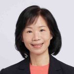 Porträt einer Frau mit schulterlangem dunklem Haar, die freundlich in die Kamera lächelt und einen dunklen Blazer trägt.